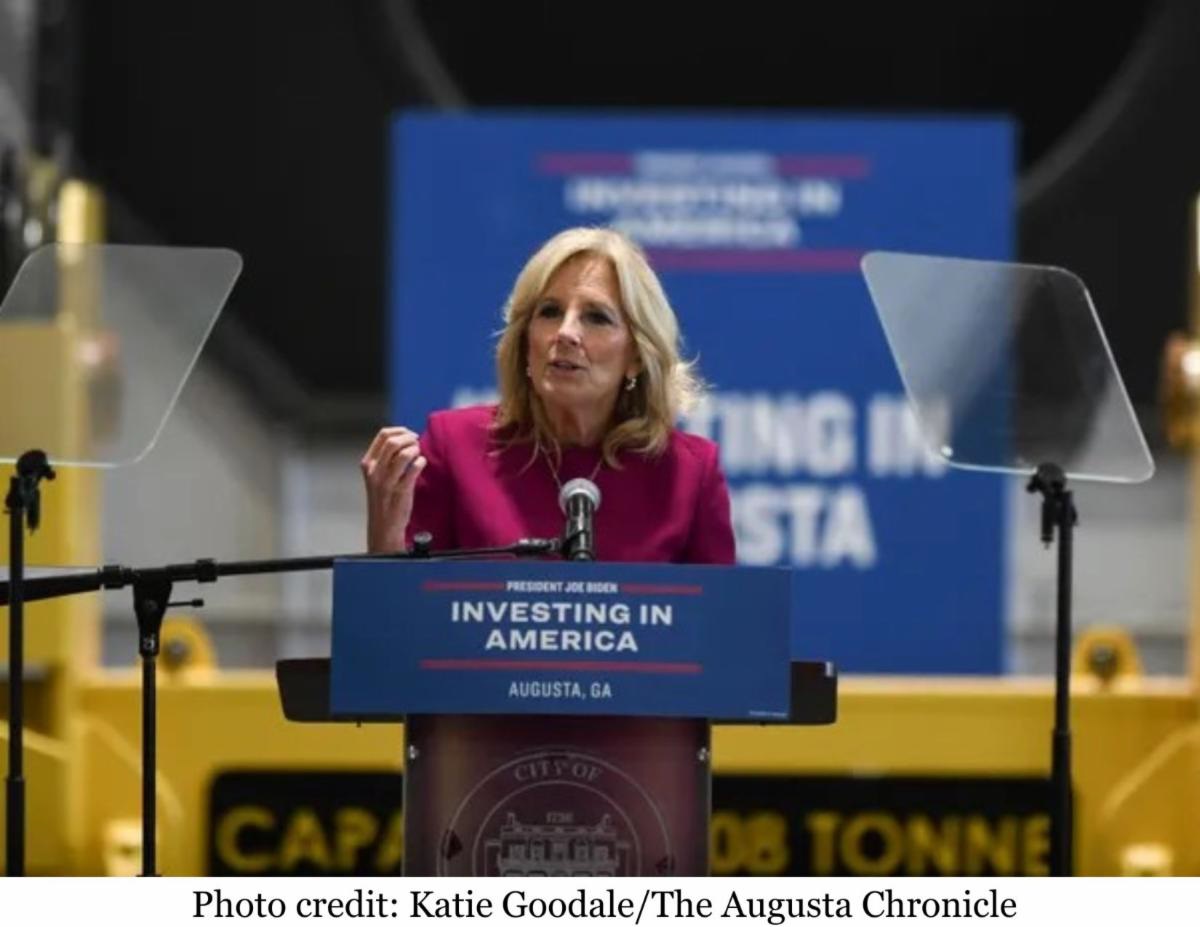 Dr. Jill Biden speaks from behind a podium featuring a blue sign labeled President Joe Biden Investing in America Augusta, GA in white font. Photo credit: Katie Goodale/The Augusta Chronicle.