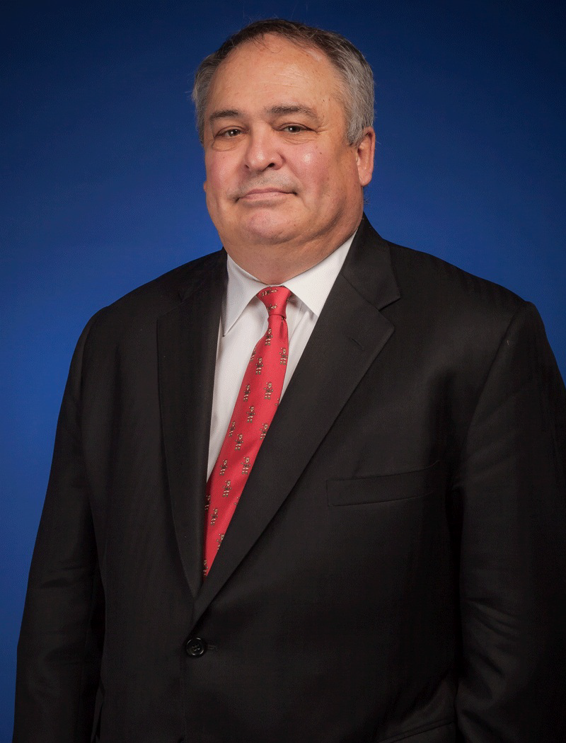 Dr. David E. Altig, a Caucasian male with short gray hair smiles wearing suite and red tie.